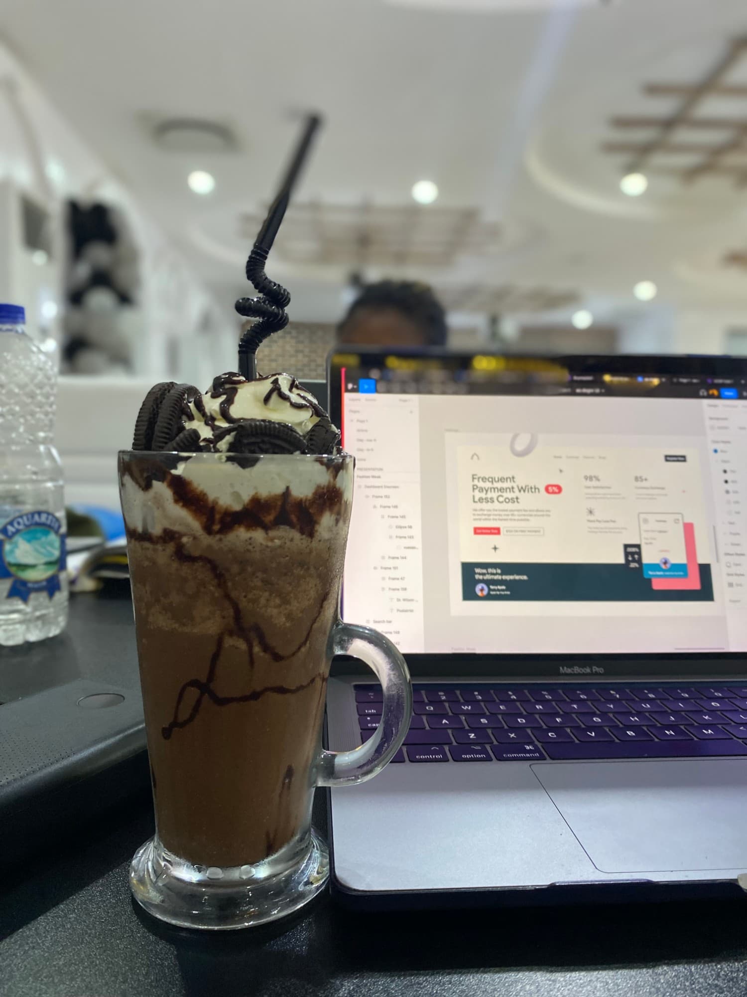 An Oreo milkshake beside a MacBook with a payments landing page open in Figma
